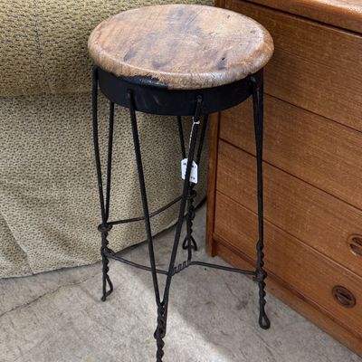 Sale Photo Thumbnail #13: Rustic plant stand or tall stool featuring a round wooden top set on a dark twisted wrought iron base.