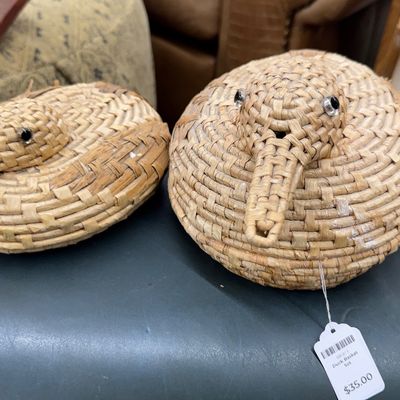 Sale Photo Thumbnail #5: Pair of woven straw duck-shaped baskets with bead eyes, featuring removable lids and textured folk art details.