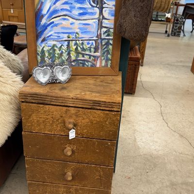 Sale Photo Thumbnail #32: Rustic four-drawer wooden chest featuring a framed expressionist painting of birds resting on its surface alongside a small dual heart picture frame.
