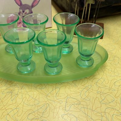 Sale Photo Thumbnail #29: Vintage green uranium glass liqueur set featuring six small footed cordials resting on a matching satin finish oval tray.
