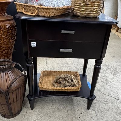 Dark espresso wooden nightstand or side table featuring two drawers, silver-tone pulls, a lower shelf display, and woven storage baskets.