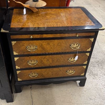 Sale Photo Thumbnail #24: Campaign-style burl wood three-drawer chest featuring black painted trim, brass hardware, and corner accents.