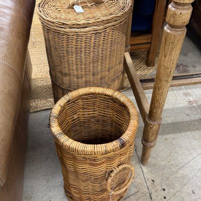 Sale Photo Thumbnail #16: Two woven wicker storage baskets, including a tall lidded hamper and an open cylindrical basket with side handles.