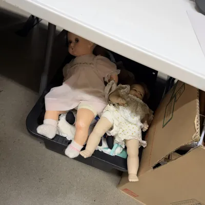 Pair of vintage baby dolls wearing lace dresses, shown with minor wear consistent with age.