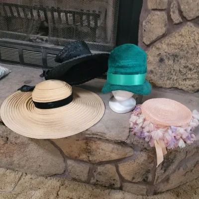 Sale Photo Thumbnail #16: Collection of mid-century vintage women's hats, including wide-brim straw hats, a green fur-felt cloche on a mannequin head, and a floral pillbox hat.