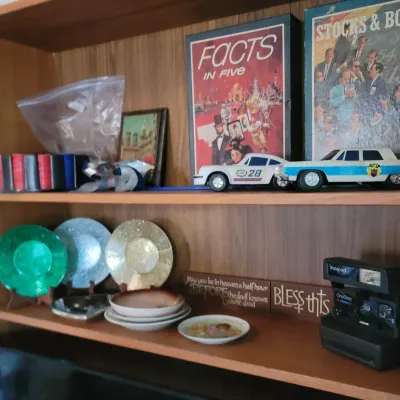 Sale Photo Thumbnail #39: Vintage board games, toy cars, decorative plates, and a Polaroid OneStep CloseUp instant camera.