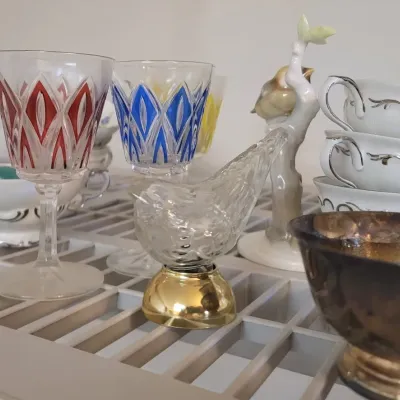 Sale Photo Thumbnail #31: Collection of vintage glassware and tableware, including red and blue cut-to-clear stemware, porcelain teacups, and figurines.