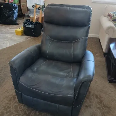 Contemporary dark gray leather recliner featuring contrast white stitching and a plush high-back design.