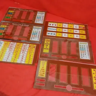Collection of vintage slot machine belly and payout glass inserts, featuring various game formats and payout schedules.