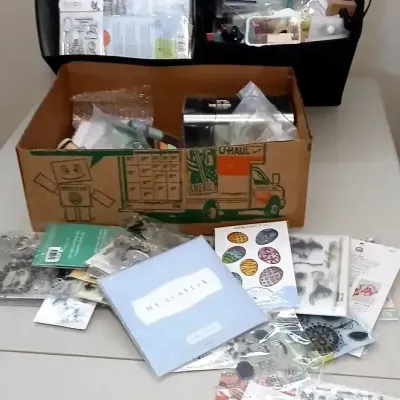 Large collection of paper crafting and scrapbooking supplies, including clear acrylic stamps, ink pads, and storage bins filled with...