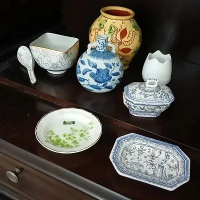 Collection of decorative porcelain and ceramic tableware, featuring blue and white pieces, a small yellow motif vase, and an Irish...