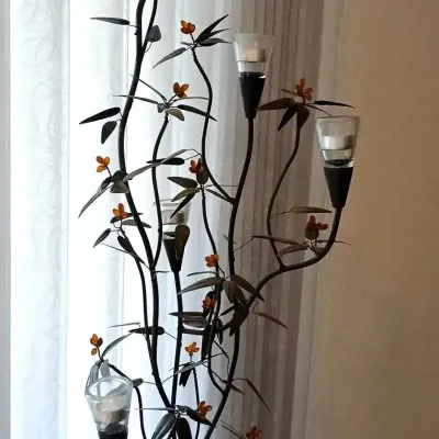 Contemporary wrought iron floor-standing candelabra featuring a botanical vine design with amber glass accents and tea light holders.