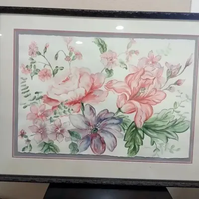 Framed floral watercolor painting under glass, featuring soft pastel pink, purple, and green blossoms, signed by the artist in the lower...
