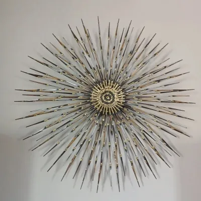 Mid-century modern C. Jere-style starburst metal wall sculpture with brass and torch-cut steel accents.