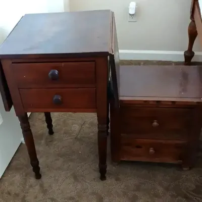 Vintage drop-leaf side table with two drawers and turned legs, positioned alongside a matching low wooden step stool or chest.