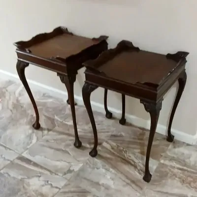 Pair of Chippendale-style dark wood tea tables featuring gallery tops, carved knees, and cabriole legs ending in ball-and-claw feet.