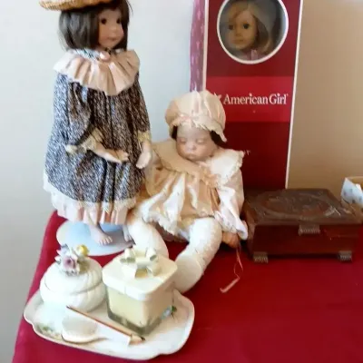Collection of collectible porcelain dolls, an American Girl doll in its original box, an inlaid wooden jewelry box, and a small vanity...