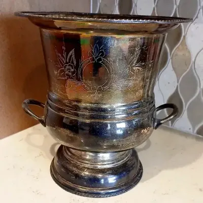 Vintage silver-plated champagne or wine bucket with side handles, featuring etched floral and wreath motifs with visible tarnishing.