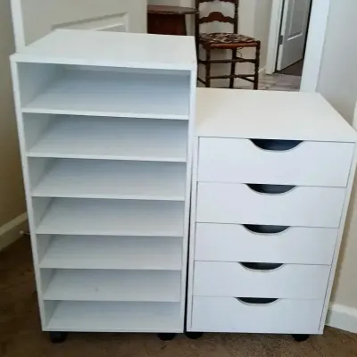 Pair of modern white rolling storage units, including an open multi-shelf organizer and a five-drawer cabinet.