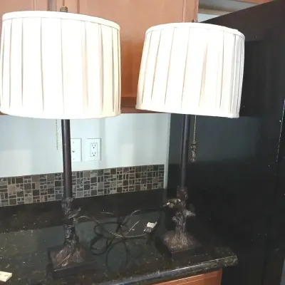 Pair of modern table lamps featuring bronze-tone faux tree trunk bases and off-white pleated drum shades.