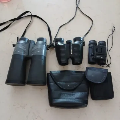 Collection of three modern binoculars, including a pair of Nikon Travelite III compact binoculars with its original soft case.