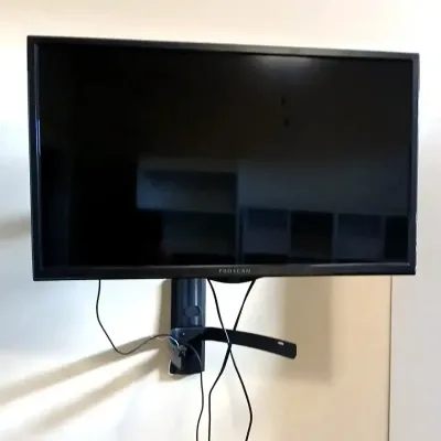 Proscan flat-screen television with a black bezel, mounted on an adjustable wall bracket.