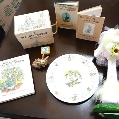 Collection of Beatrix Potter memorabilia, including vintage books, a boxed book set, a decorative ceramic plate, a small figurine, and a...