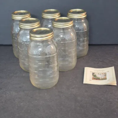 Sale Photo Thumbnail #40: Set of six Longaberger embossed glass canning jars with brass-toned lids and original insert booklet.