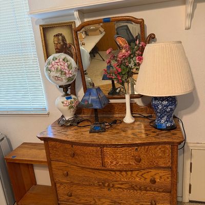 Antique quarter-sawn oak dresser with attached mirror, displaying several tabletop lamps and decor items.