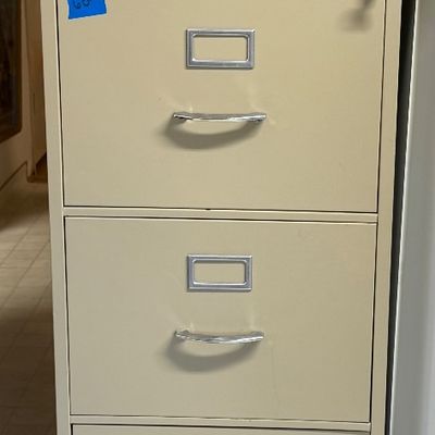 Four-drawer beige metal filing cabinet with silver handles and label holders Fire King