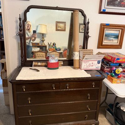 Vintage dark wood dresser with attached shaped mirror, brass drop-handle hardware, and cabriole legs.
