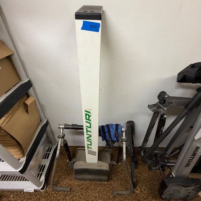 Vintage Tunturi home rowing machine with a white central column and dual resistance hydraulic arms.