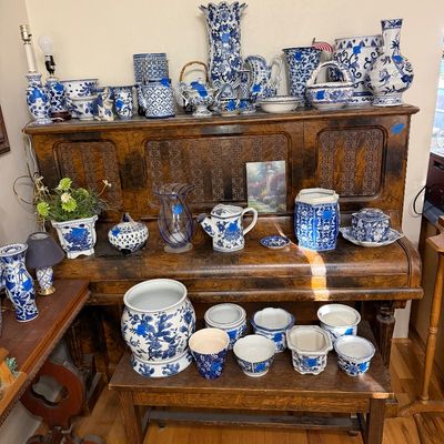 Large collection of blue and white chinoiserie porcelain ceramics, including vases, ginger jars, teapots, and planters, arranged on a...