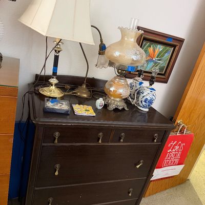 Sale Photo Thumbnail #108: Dark wood vintage dresser featuring cabriole legs and brass hardware, topped with various table lamps, an oil lamp, and small collectibles.