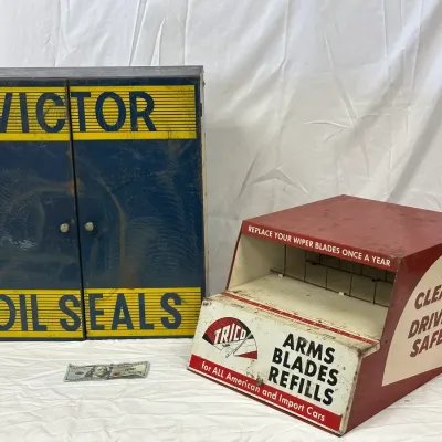 Vintage metal advertising display cabinets, including a blue Victor Oil Seals wall cabinet and a red Trico wiper blade counter display box.