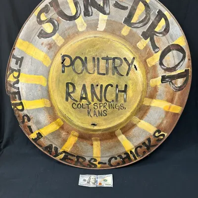 Vintage hand-painted metal sign for Sun-Drop Poultry Ranch in Colt Springs, Kansas, featuring rustic weathered details and sunburst design.