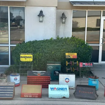 Collection of vintage automotive advertising displays, metal oil cans, and parts cabinets, including brands such as Bardahl, Sinclair,...