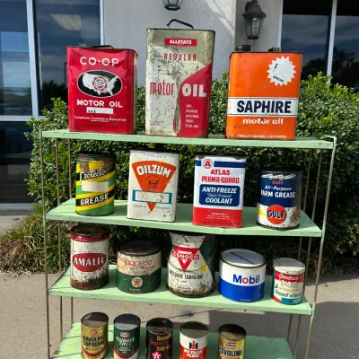 Collection of vintage mid-20th century oil, lubricant, and grease cans from brands like Co-Op, Allstate, Texaco, Mobil, and Gulf,...