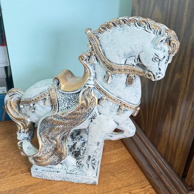Vintage plaster or resin carousel horse floor statue with a whitewashed finish and ornate gold-painted tack.