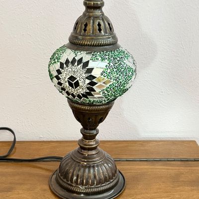 Turkish mosaic table lamp with green, silver, and black glass tiles set in an antique brass-toned metal base and finial.