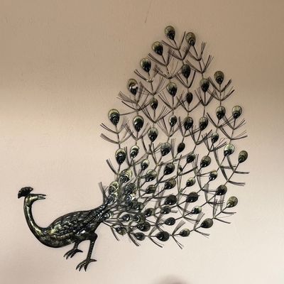 Vintage mid-century brass peacock wall sculpture featuring an intricate fan of wire and stamped-metal tail feathers.