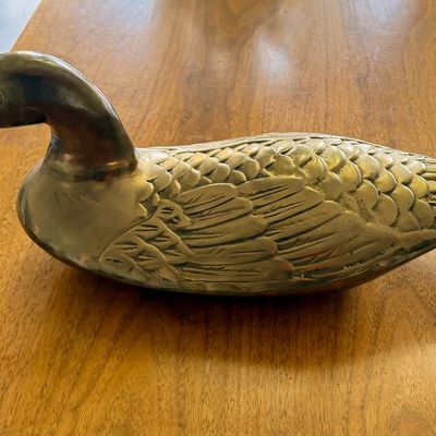 Vintage brass duck decoy figurine featuring detailed feather texturing and a light age patina.