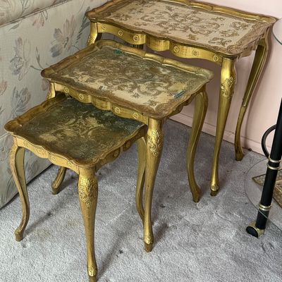 Vintage Florentine Italian three-tier nesting tables with gilt finish and embossed scrollwork tops.
