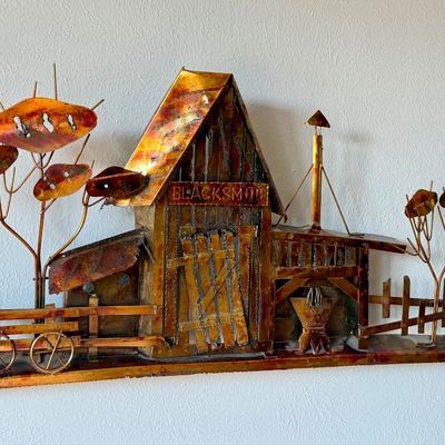 Mid-century modern 3D copper metal wall sculpture depicting a blacksmith shop scene with trees and a fence.