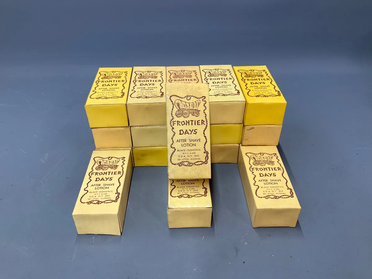 Sale Photo Thumbnail #361: Collection of vintage Frontier Days after shave lotion boxes by Blake Cosmetics featuring covered wagon graphics.