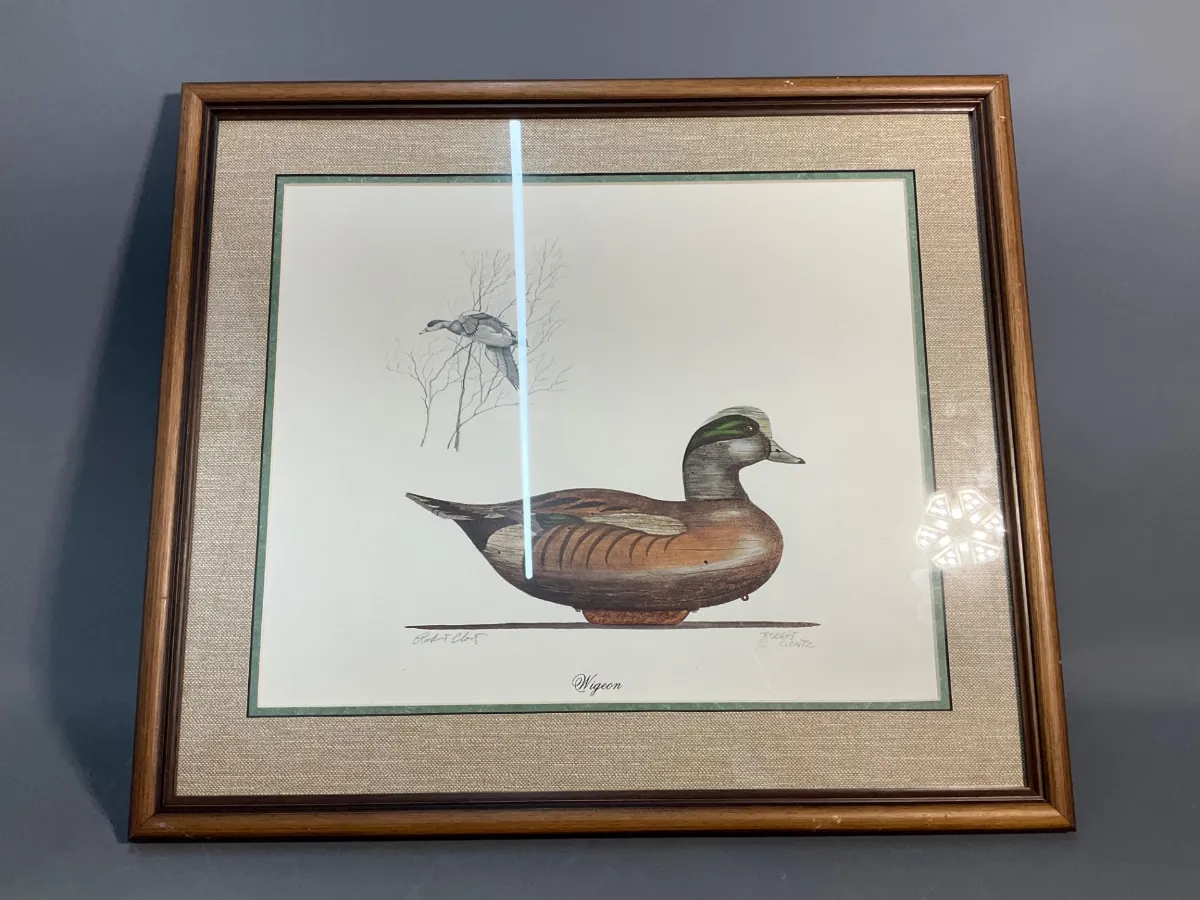 Sale Photo Thumbnail #78: Framed and matted art print titled "Wigeon" depicting a duck and decoy, housed in a wooden frame with a fabric mat.