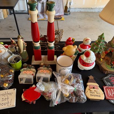 Sale Photo Thumbnail #131: Collection of holiday decorations, featuring tall red and green painted wooden candlesticks, Santa figurines, countdown signs, and a festive table lamp.