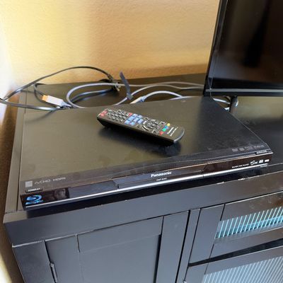 Panasonic DMP-BD60 Blu-ray disc player in black, accompanied by its matching remote control and power cord.