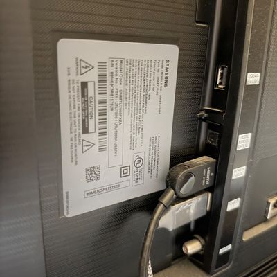 Back panel of a Samsung model UN65TU7000F 65-inch Smart TV showing inputs, serial number sticker, and manufacture date of August 2021.