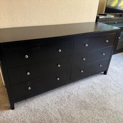 Contemporary black wood six-drawer dresser featuring silver round knobs and a sleek design.